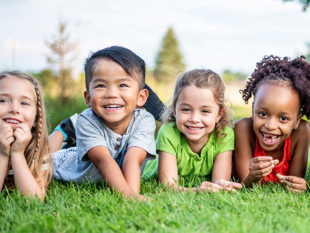 group of kids laying in grass
